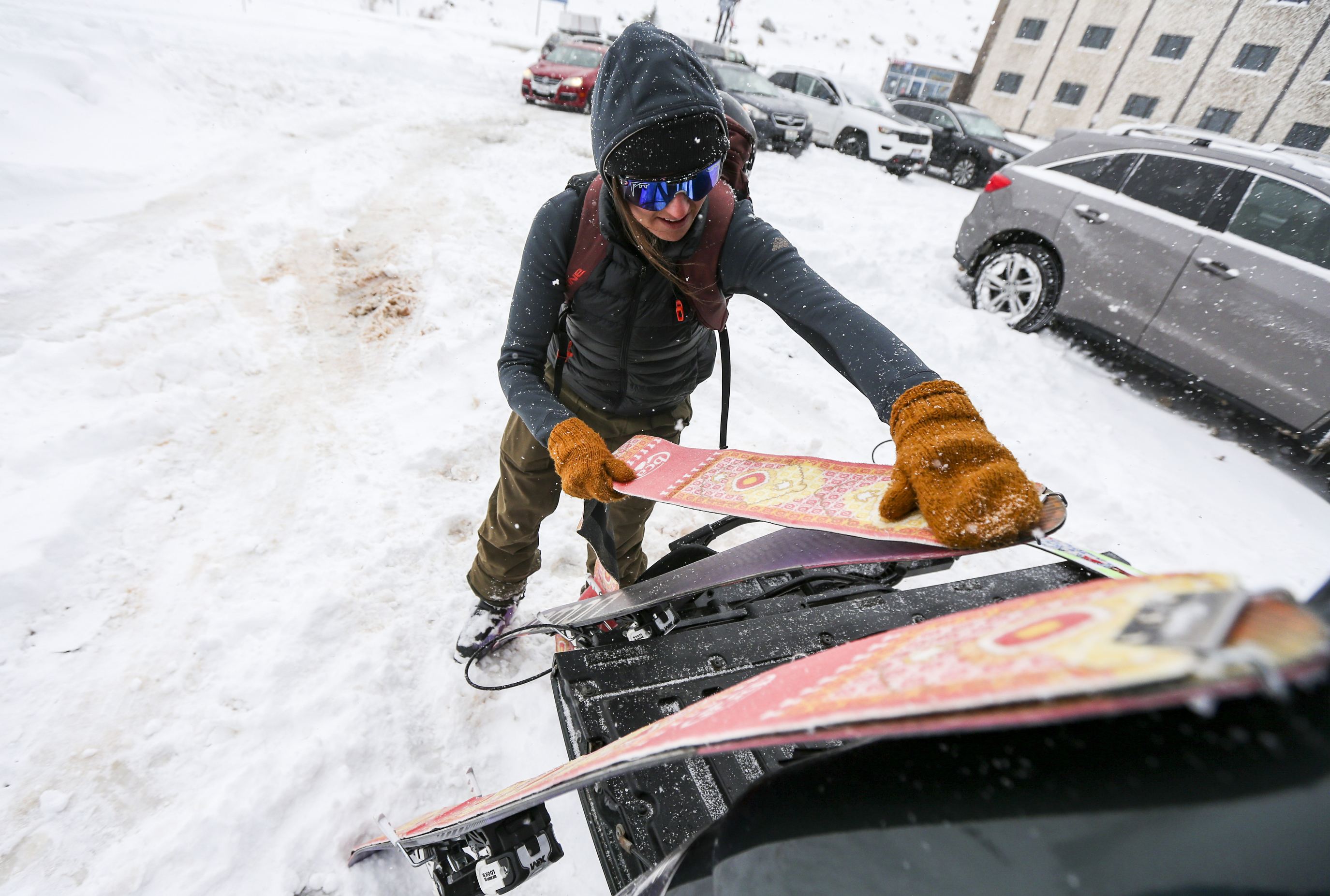 Georgie Knox puts the skins on her skis as she prepares to head up the hill from the Wildcat base area at Alta Ski Resort in Little Cottonwood Canyon to enjoy the first substantial snowfall of the year on Sunday, Oct. 20, 2019. (Colter Peterson, KSL)