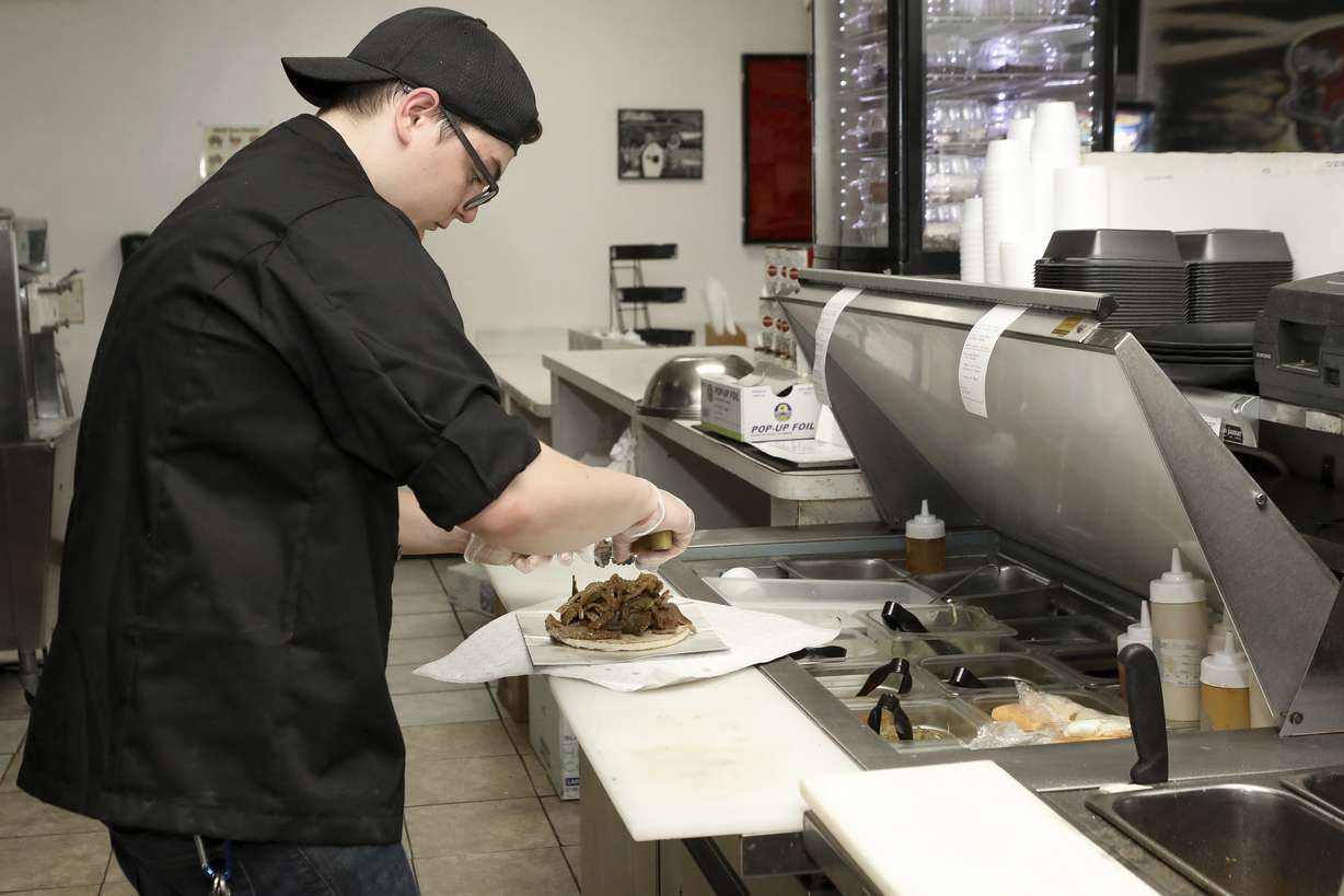 Chef Joseph Gattuso prepares a gyro sandwich in Schaumburg, Ill., on Sept. 6, 2019. He's working in the kitchen of Frato's Pizza, but filling an online order for the virtual restaurant Halal Kitchen. (Teresa Crawford, AP Photo)