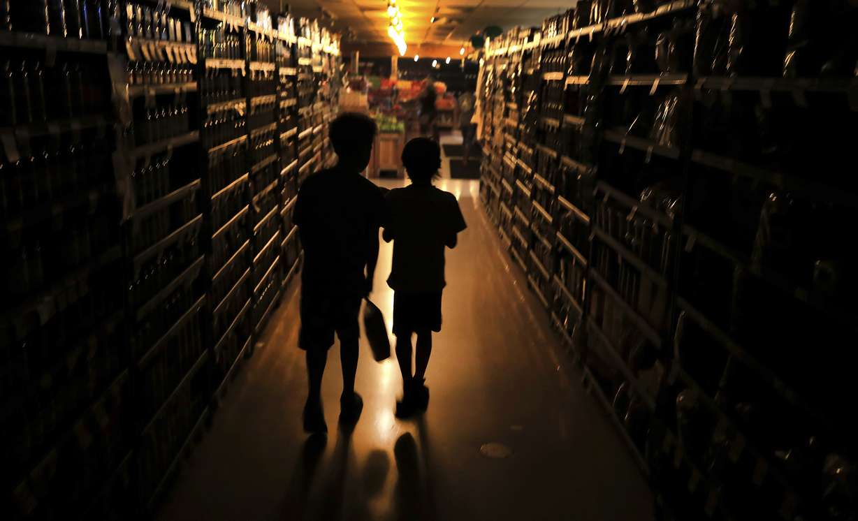 Elijah Carter 11, left, and Robert Haralson, 12, help shop for their parents in a darkened Olivers Supermarket in the Rincon Valley community, Wednesday, Oct. 23, 2019, in Santa Rosa, Calif. Photo: Kent Porter, The Press Democrat via AP