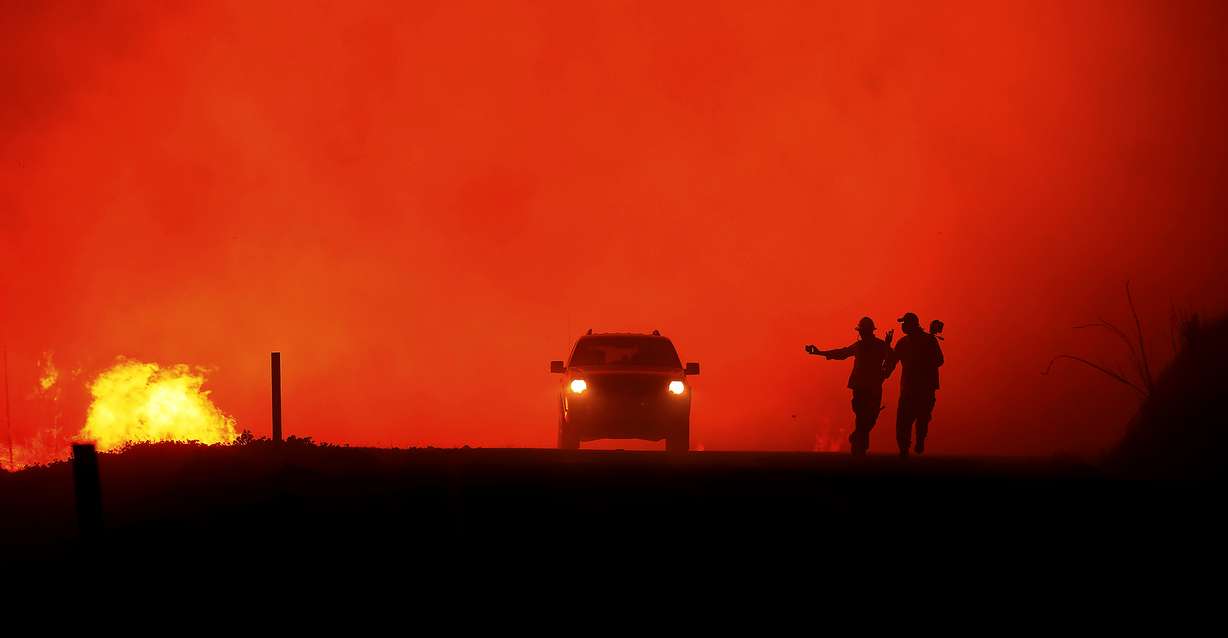 Photographers documenting the Kincade fire in the Geysers run as the fire approaches Geysers Road, Thursday, Oct. 24, 2019, in Sonoma County, Calif. (Kent Porter/The Press Democrat via AP)