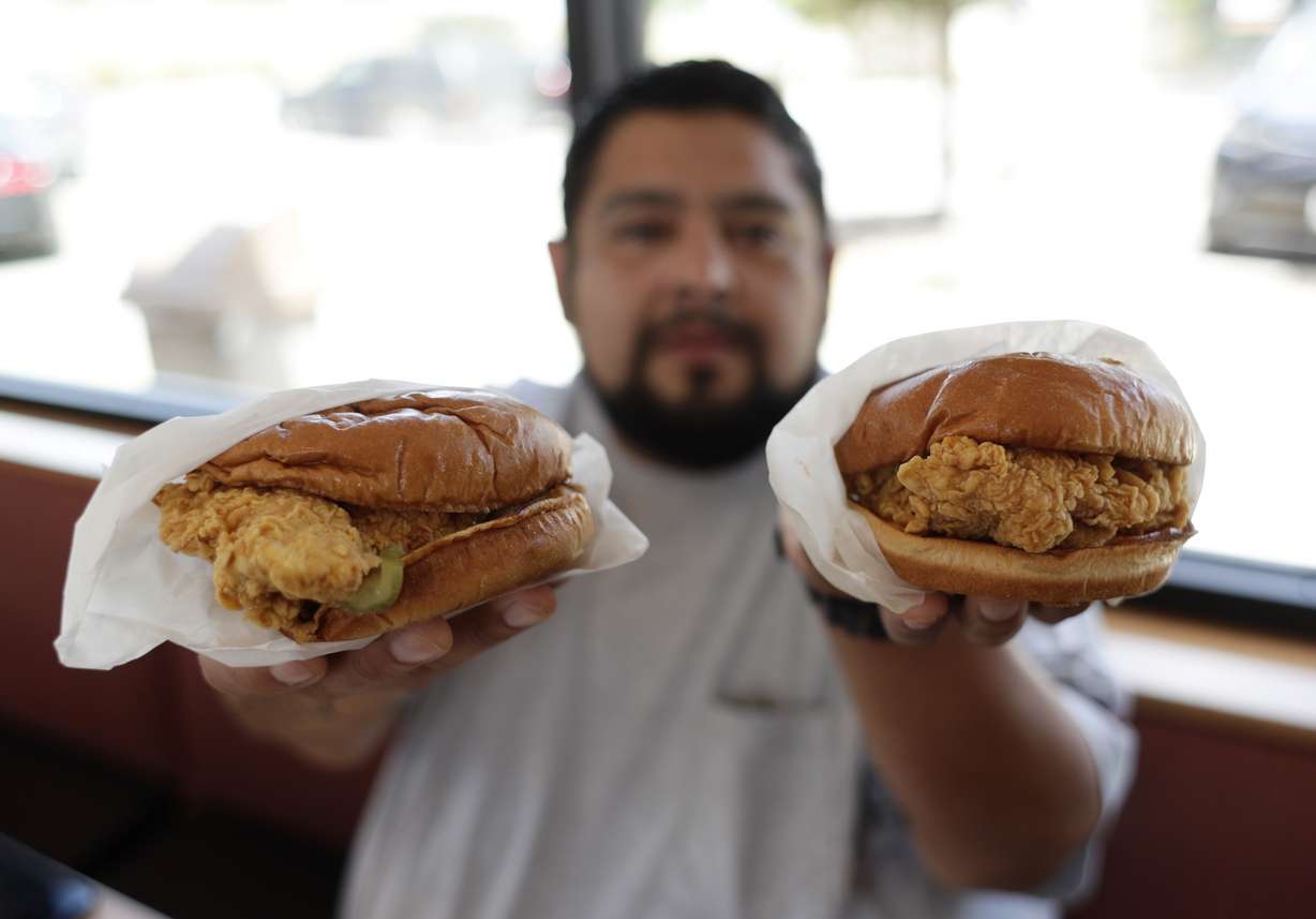 Randy Estrada holds up chicken sandwiches at a Popeyes, Thursday, Aug. 22, 2019, in Kyle, Texas. (Photo: Eric Gay, AP Photo.)