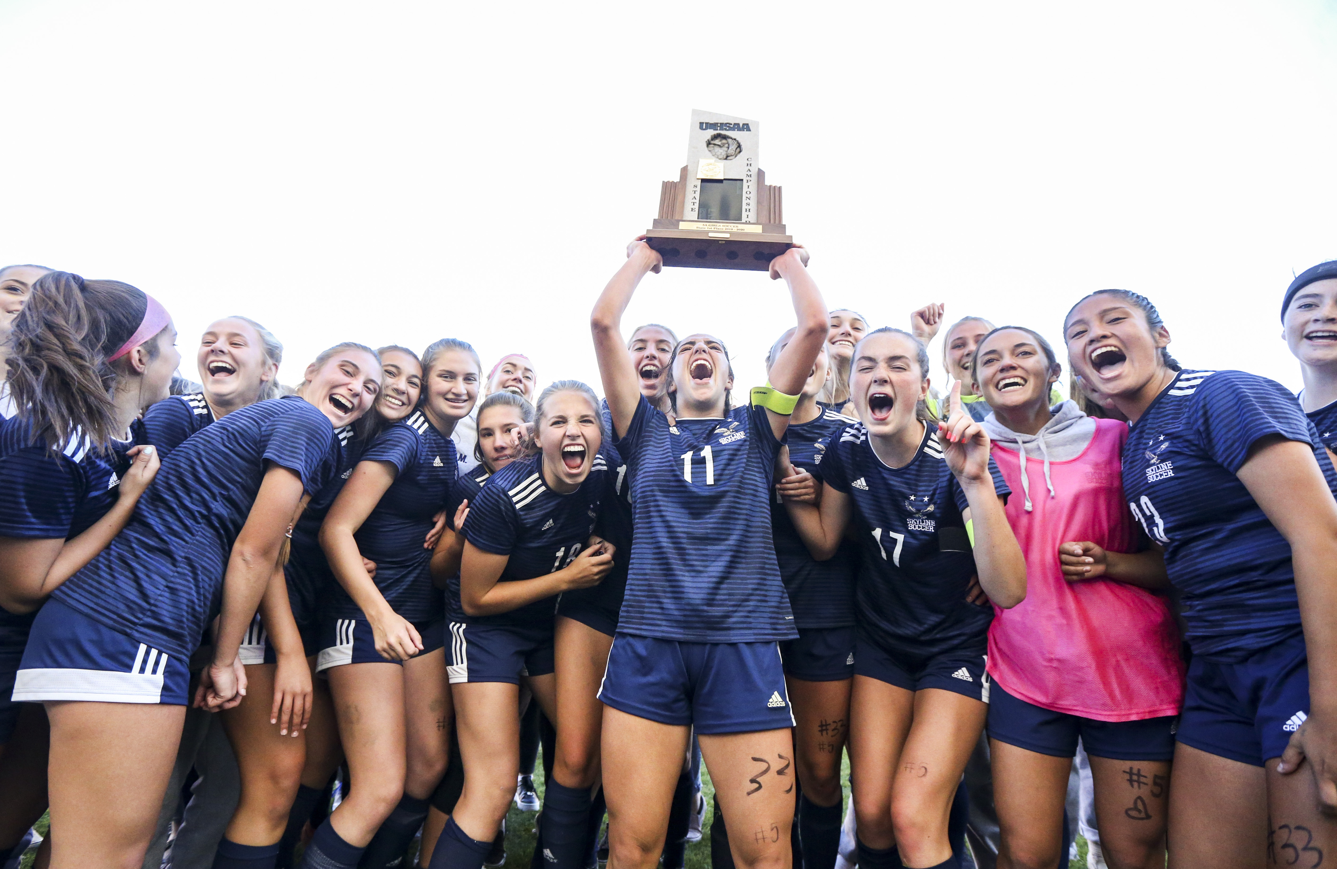 Skyline's Ani Jensen (11) hoists the team's state championship trophy into the air as they celebrate after winning the 5A girls state soccer match 2-1 over Bonneville at Rio Tinto Stadium in Sandy on Friday, Oct. 25, 2019.