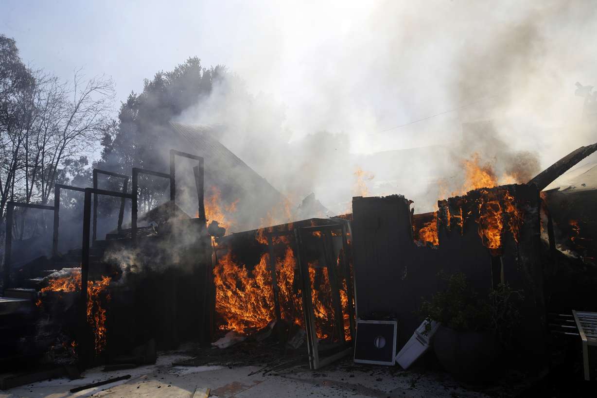 A wildfire-ravaged home burns as crews continue to battle the Getty fire Monday, Oct. 28, 2019, in Los Angeles. (AP Photo/Marcio Jose Sanchez)