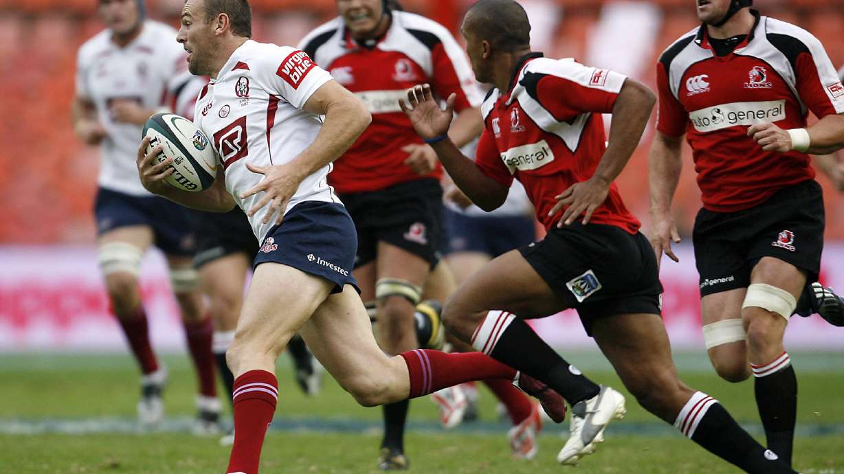 Australia's Reds Chris Latham, left, attacks as South Africa's Lions Dusty Noble, second from right, vies for the ball during their Super14 rugby match at the Ellis Park stadium in Johannesburg, South Africa, Saturday, March 22, 2008. The match ended in a 24-all draw. (AP Photo)