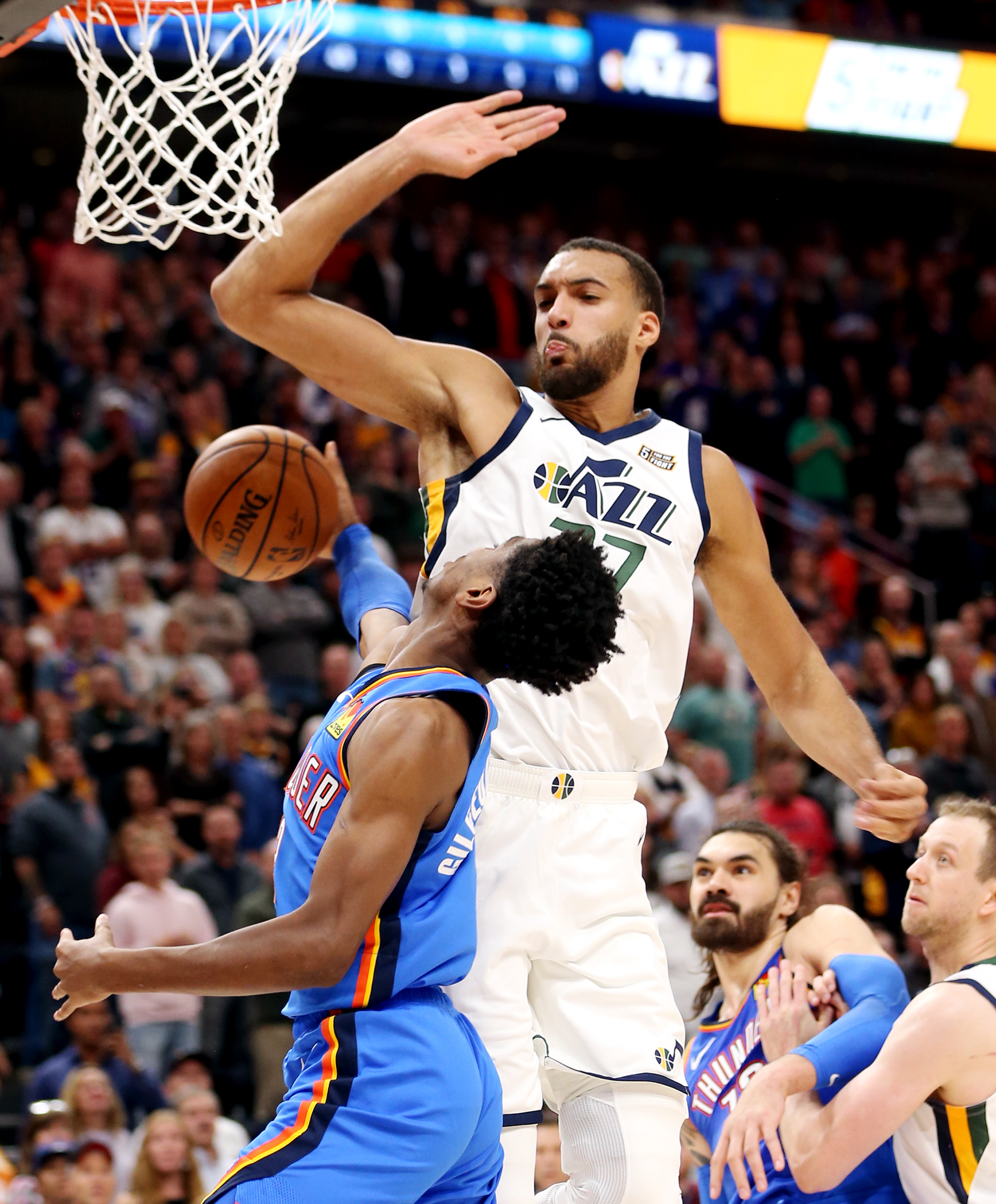 Utah Jazz center Rudy Gobert (27) defends Oklahoma City Thunder guard Shai Gilgeous-Alexander (2) under the basket as the Jazz open the 2019-20 season with a 100-95 win at Vivint Smart Home Arena in Salt Lake City on Wednesday, Oct. 23, 2019. (Scott G Winterton, KSL)