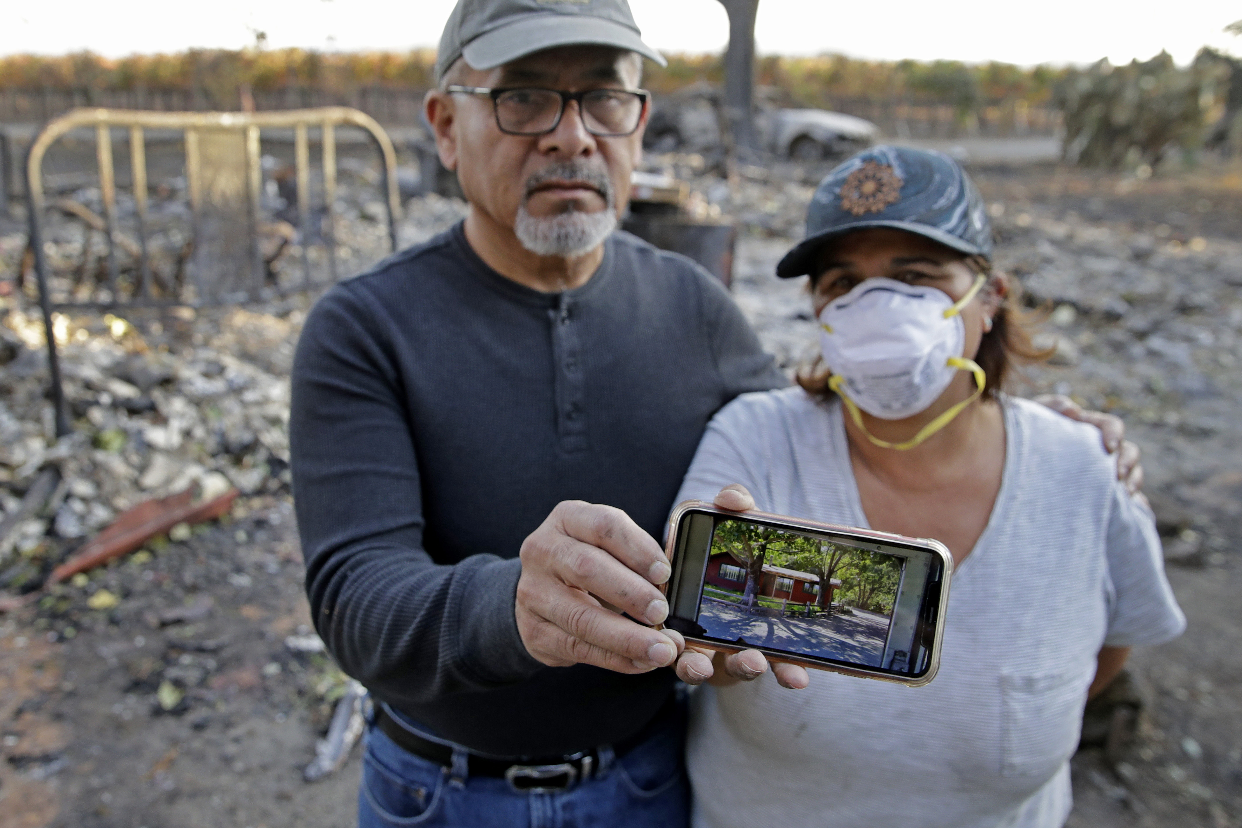 Justo and Bernadette Laos show a photo of the home they rented that was destroyed by the Kincade Fire near Geyserville, Calif., Thursday, Oct. 31, 2019. The fire started last week near the town of Geyserville in Sonoma County north of San Francisco. (Charlie Riedel, AP Photo)