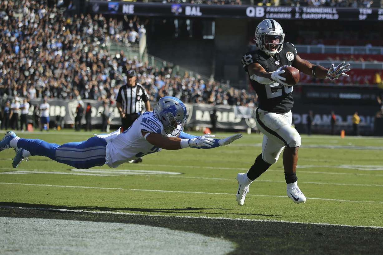 Oakland Raiders running back Josh Jacobs (28) runs for a touchdown past Detroit Lions defensive back Miles Killebrew during the first half of an NFL football game in Oakland, Calif., Sunday, Nov. 3, 2019. (AP Photo/John Hefti)
