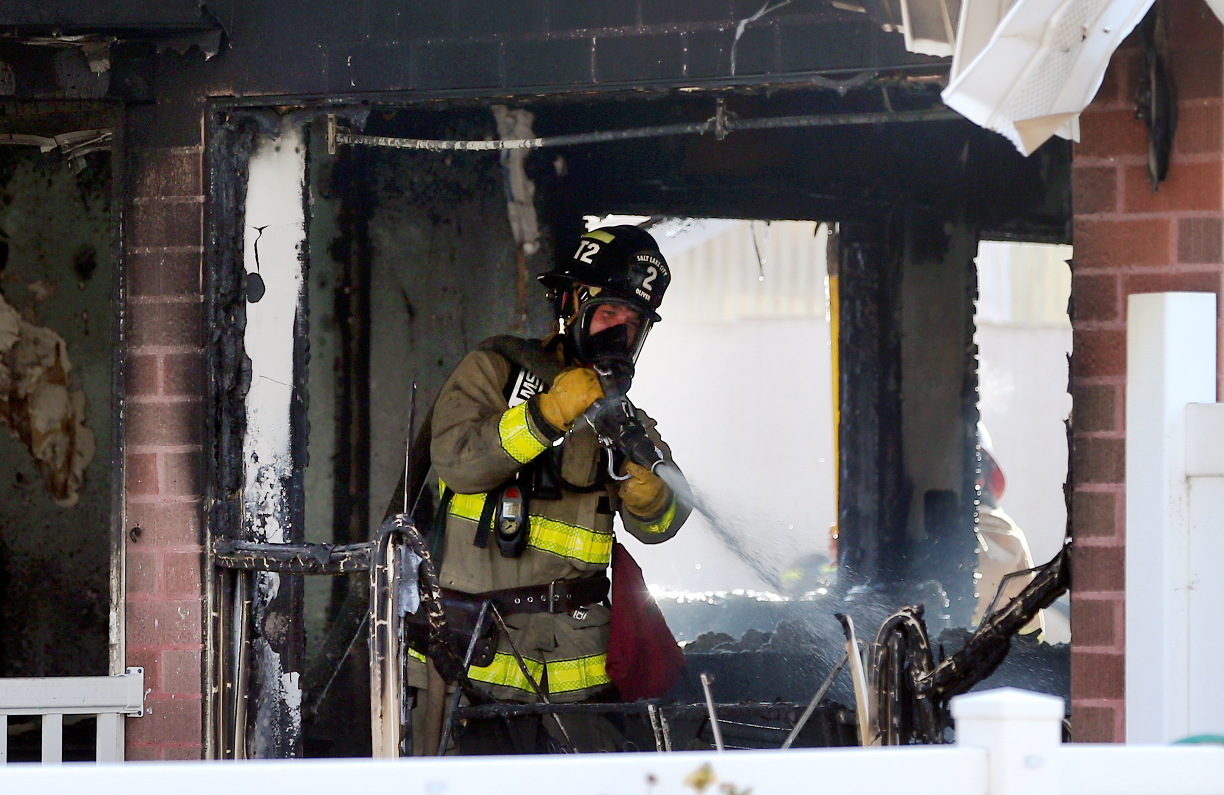 A Salt Lake City firefighter puts water on hot spots inside a home at 923 N. 1500 West on Monday, Nov. 4, 2019. A couple and their newborn were able to escape without injury, but their cat was killed. (Photo: Scott G Winterton, KSL)