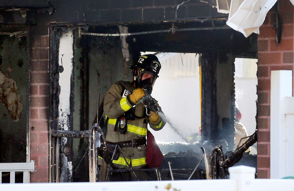 A Salt Lake City firefighter puts water on hot spots inside a home at 923 N. 1500 West on Monday, Nov. 4, 2019. A couple and their newborn were able to escape without injury, but their cat was killed. (Photo: Scott G Winterton, KSL)