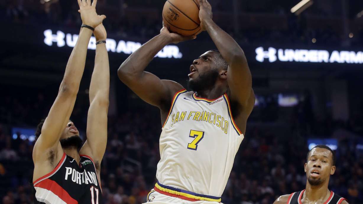 Golden State Warriors forward Eric Paschall (7) shoots between Portland Trail Blazers forward Skal Labissiere, left, and forward Rodney Hood during the first half of an NBA basketball game in San Francisco, Monday, Nov. 4, 2019.