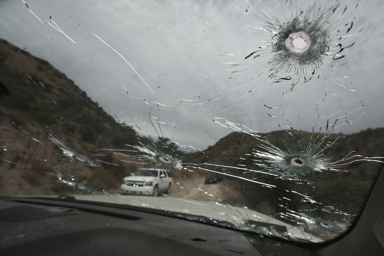 Bullet-riddled vehicles that members of the extended LeBaron family were traveling in sit parked on a dirt road near Bavispe, at the Sonora-Chihuahua state border, Mexico, Wednesday, Nov. 6, 2019. (AP Photo/Christian Chavez)
