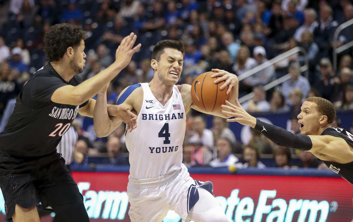 Brigham Young Cougars guard Alex Barcello (4) runs through San Diego State Aztecs guards Jordan Schakel (20) and Malachi Flynn (22) during the first half of a NCAA basketball game at Marriott Center in Provo on Saturday, Nov. 9, 2019. (Photo: Colter Peterson, KSL)