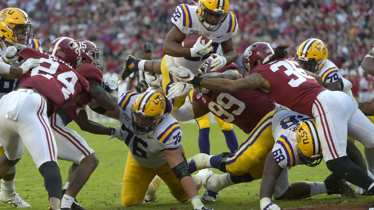 LSU running back Clyde Edwards-Helaire (22) dives over Alabama's Raekwon Davis (99) and Markail Benton (36) to score a touchdown in the first half of an NCAA college football game, Saturday, Nov. 9, 2019, in Tuscaloosa, Ala. (AP Photo/Vasha Hunt)