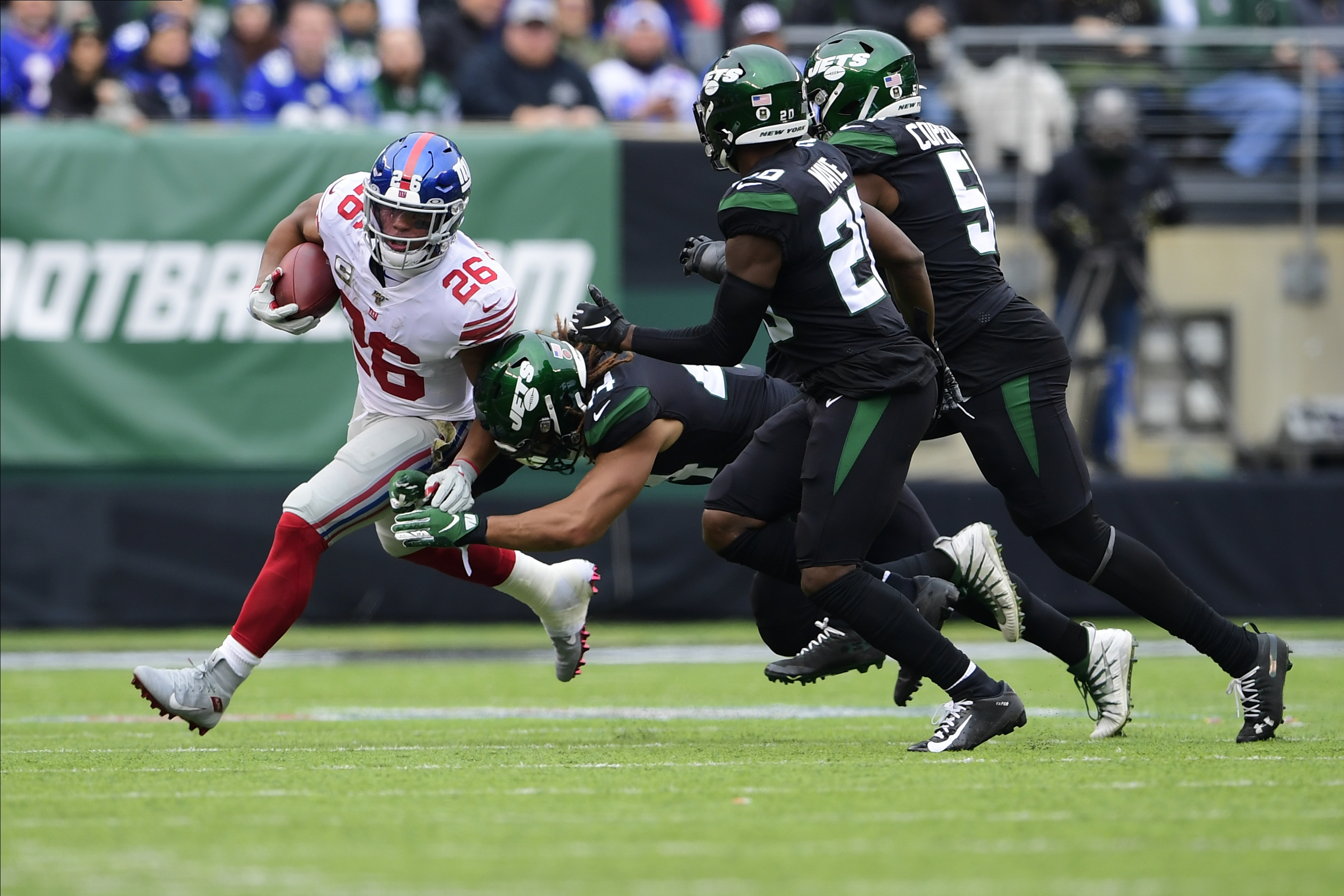 New York Giants' Saquon Barkley evades a tackle by New York Jets' Harvey Langi (44), Marcus Maye (20) and Brandon Copeland (51) during the first half of an NFL football game Sunday, Nov. 10, 2019, in East Rutherford, N.J.