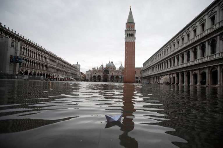 A boat made with a paper sheet floats in a flooded St. Mark's Square at Venice, Friday, Nov. 15, 2019.The high-water mark hit 187 centimeters (74 inches) late Tuesday, Nov. 12, 2019, meaning more than 85% of the city was flooded. The highest level ever recorded was 194 centimeters (76 inches) during infamous flooding in 1966. (AP Photo/Luca Bruno)