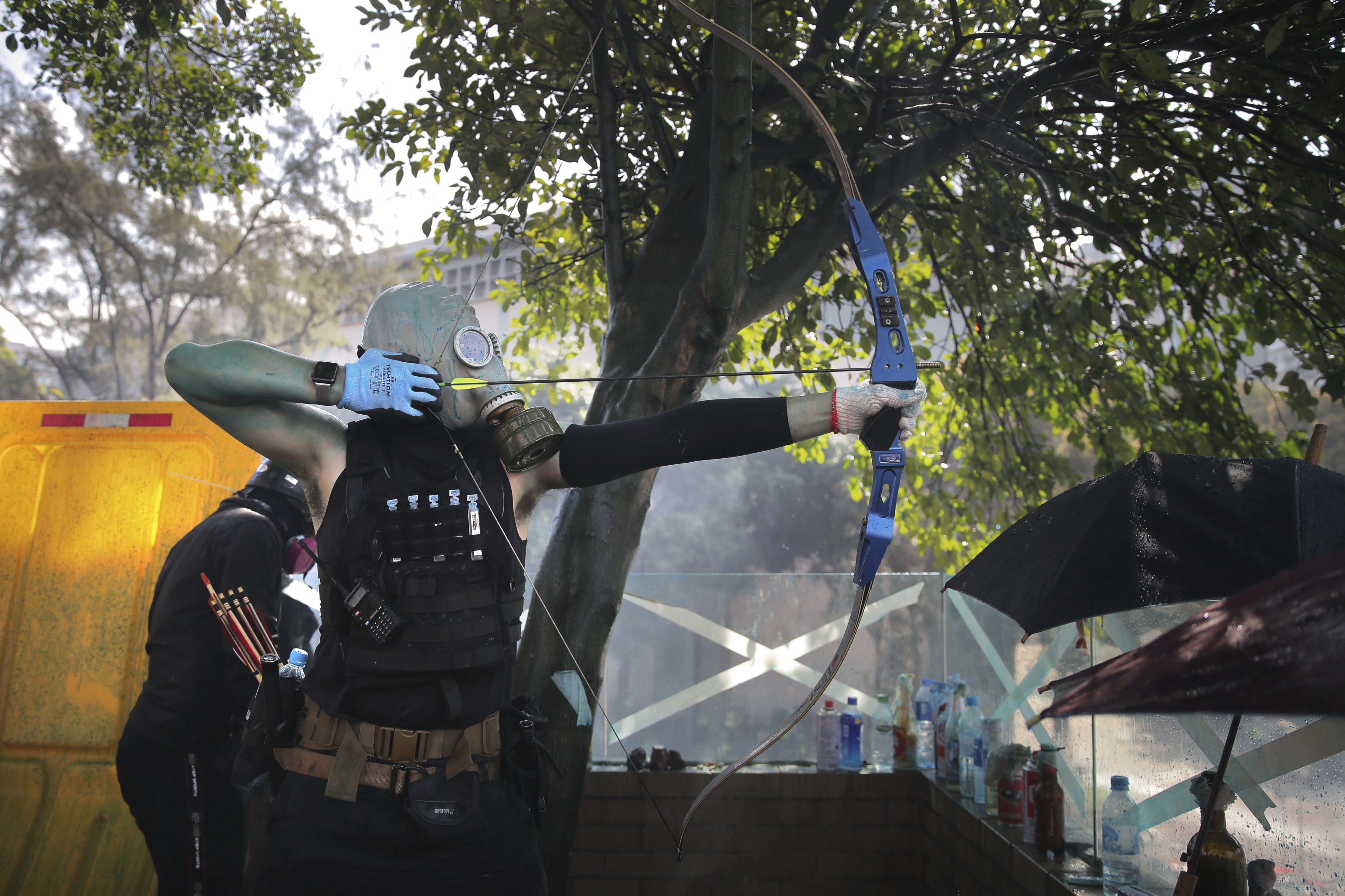 A protestor prepares to fire a bow and arrow during a confrontation with police at the Hong Kong Polytechnic University in Hong Kong, Sunday, Nov. 17, 2019. A Hong Kong police officer was hit in the leg by an arrow Sunday as authorities used tear gas and water cannons to try to drive back protesters occupying a university campus and surrounding streets. (AP Photo/Kin Cheung)