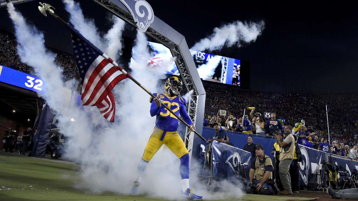 Los Angeles Rams free safety Eric Weddle carries the American flag onto the field before an NFL football game against the Chicago Bears Sunday, Nov. 17, 2019, in Los Angeles.
