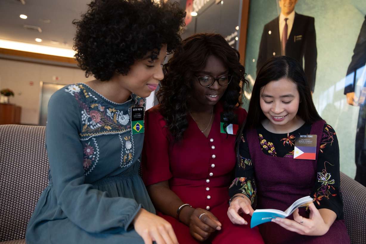 Missionaries Sister Freitas (left), from Brazil; Sister Zainab (center), from Italy; and Sister Tigno (right), from the Philippines, serving on Temple Square, review the new "missionary Standards for Disciples of Jesus Christ." (Photo: Intellectual Reserve)