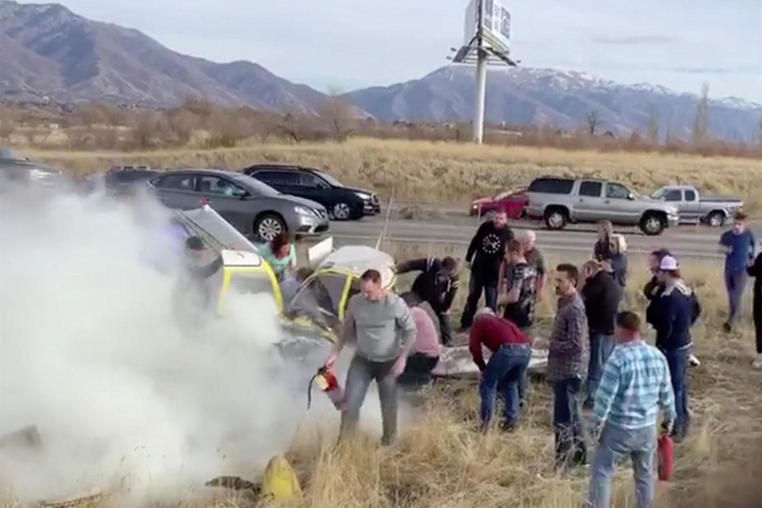 Bystanders help out after the crash of a small airplane off I-15 in Roy on Nov. 17, 2019.