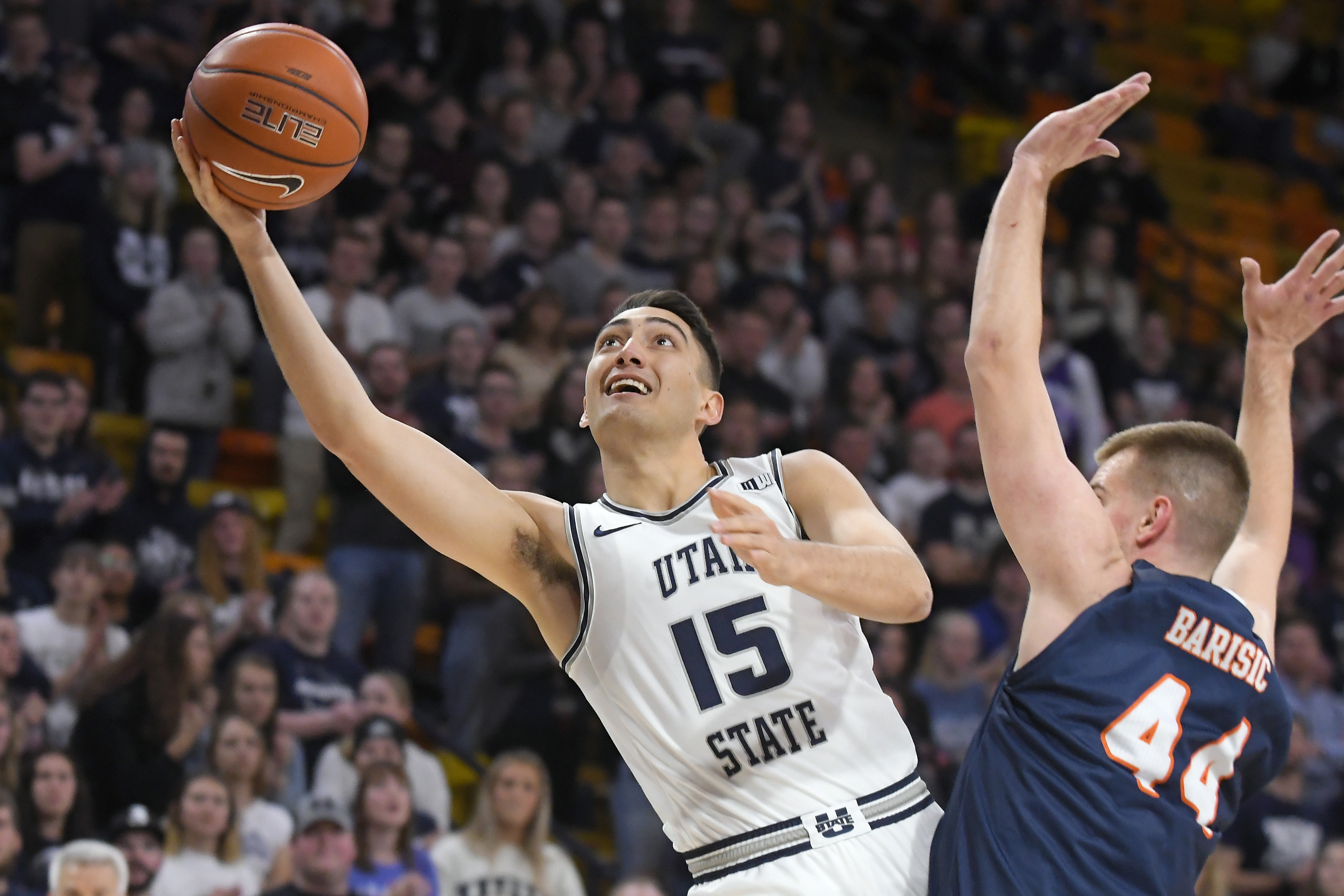 Utah State guard Abel Porter (15) takes a shot as UTSA forward Luka Barisic (44) defends during the first half of an NCAA college basketball game Monday, Nov. 18, 2019, in Logan, Utah. (AP Photo/Eli Lucero)