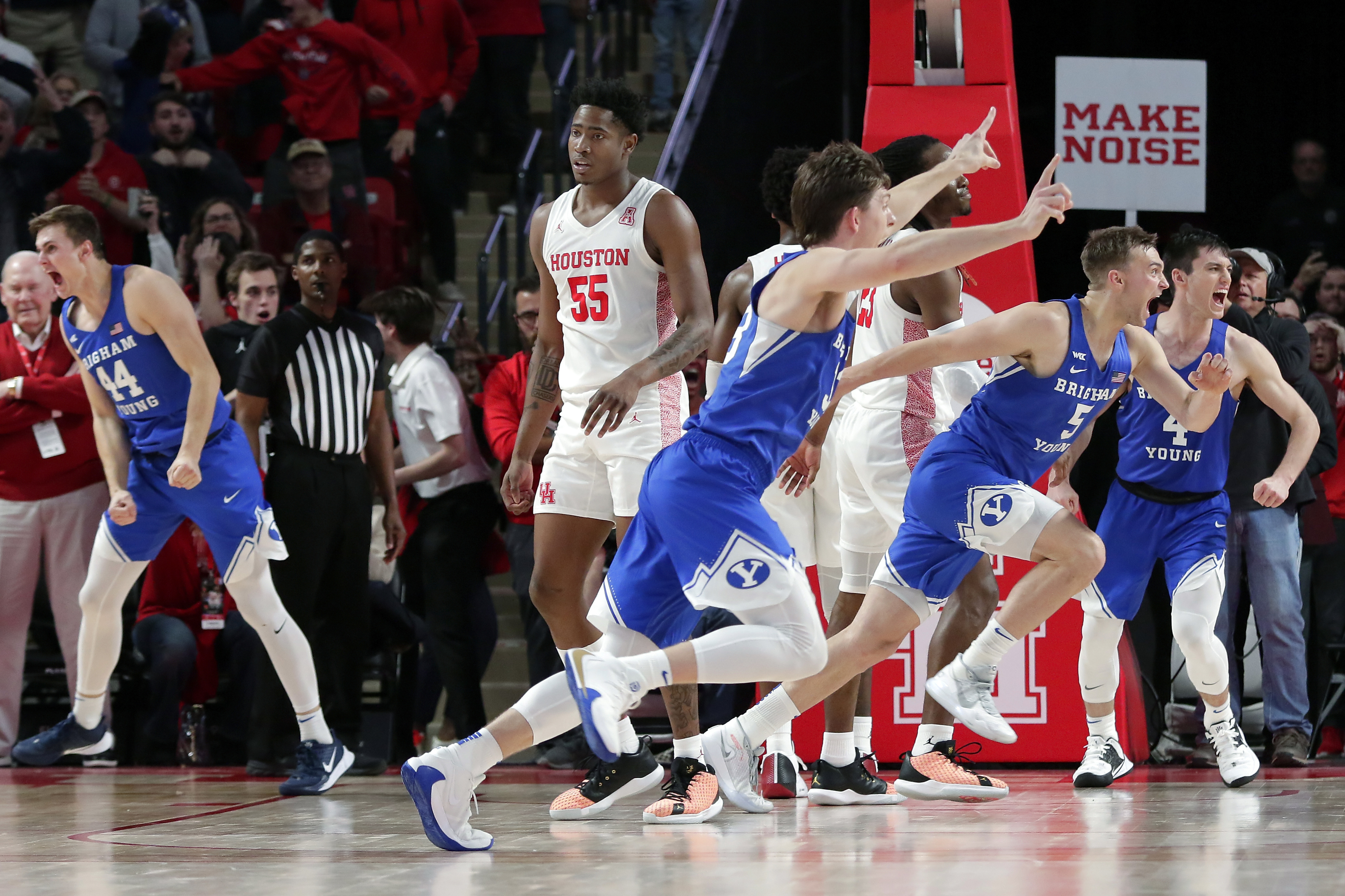 Houston center Brison Gresham (55) leaves the court as BYU players celebrate a 72-71 win during an NCAA college basketball game Friday, Nov. 15, 2019, in Houston. (Michael Wyke/Houston Chronicle via AP)
