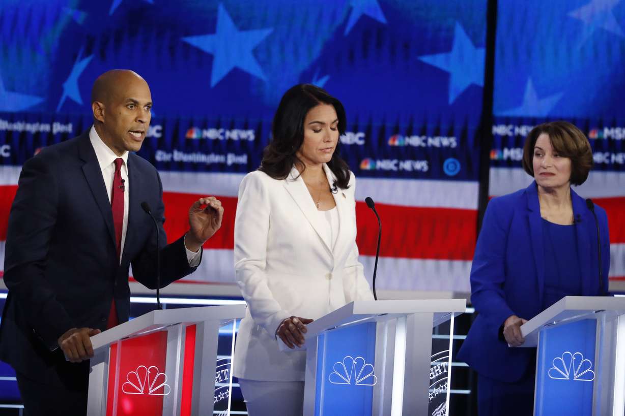 emocratic presidential candidate Sen. Cory Booker, D-N.J., left, speaks as Democratic presidential candidate Rep. Tulsi Gabbard, D-Hawaii, and Democratic presidential candidate Sen. Amy Klobuchar, D-Minn., listen during a Democratic presidential primary debate. Photo: AP Photo