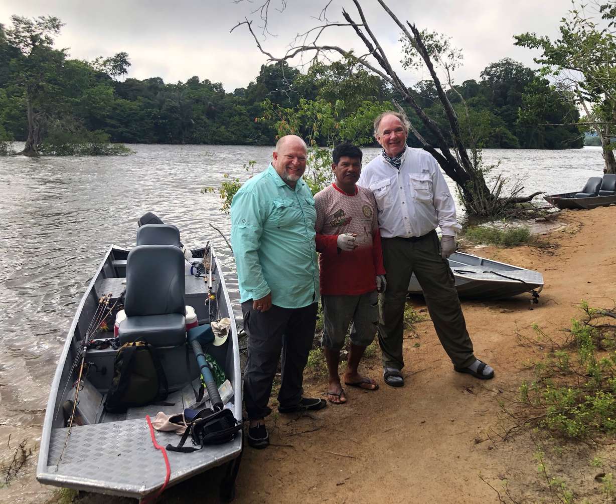 Flint Stephens with native guide Enoch and Jim Troupis from Wisconsin with the boats they used during the trip. (Photo: Flint Stephens)