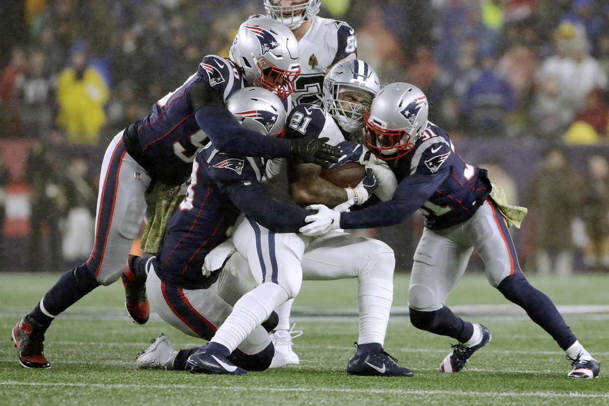 New England Patriots defenders Jamie Collins, left, Kyle Van Noy and Jonathan Jones, right, tackle Dallas Cowboys running back Ezekiel Elliott in the first half of an NFL football game, Sunday, Nov. 24, 2019, in Foxborough, Mass. (AP Photo/Elise Amendola)