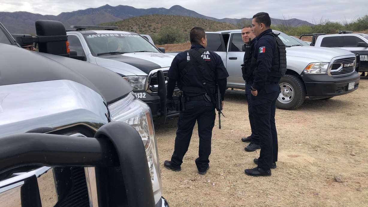 Armed officers in La Mora, Sonora state, Mexico, stand near the funeral services for three of the nine victims of an ambush attack on Thursday, Nov. 7, 2019. Three mothers and six children were killed Monday by suspected cartel members while driving in a remote, mountainous region in the state of Sonora near the border of Chihuahua. (Dan Rascon, KSL)