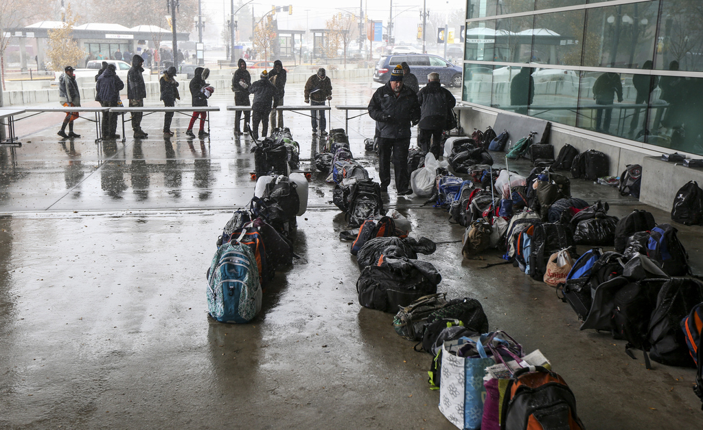 People stand in line to retrieve checked bags after eating an early Thanksgiving meal during the 21st annual "We Care - We Share" event for the homeless and low-income individuals at the Vivint Smart Home Arena in Salt Lake City on Monday, Nov. 25, 2019. The Salt Lake Mission was also on hand to provide coats, shoes and cold-weather apparel to those in attendance. (Photo: Colter Peterson, KSL)