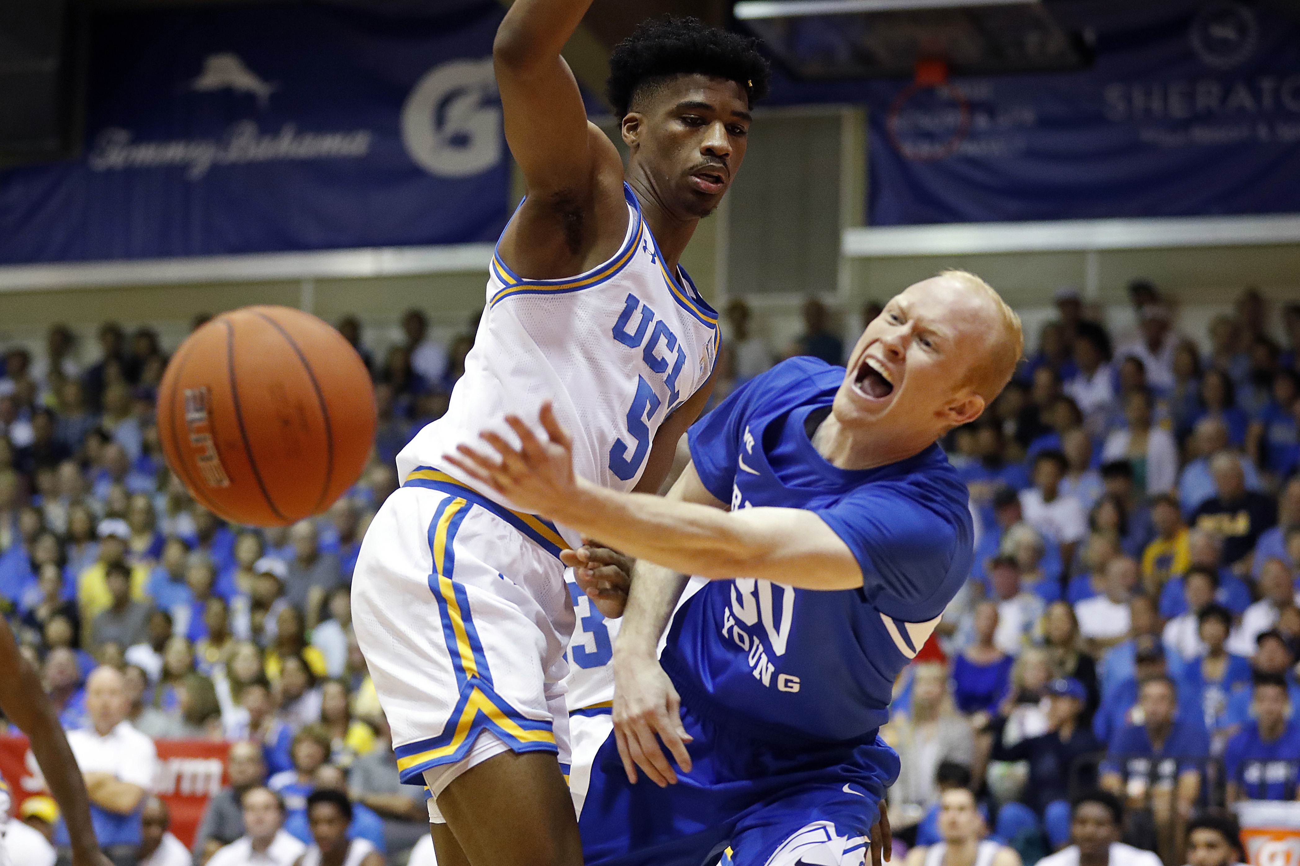 BYU guard TJ Haws (30) makes a pass while being guarded by UCLA guard Chris Smith (5) during the first half of an NCAA college basketball game, Monday, Nov. 25, 2019, in Lahaina, Hawaii. (AP Photo/Marco Garcia)