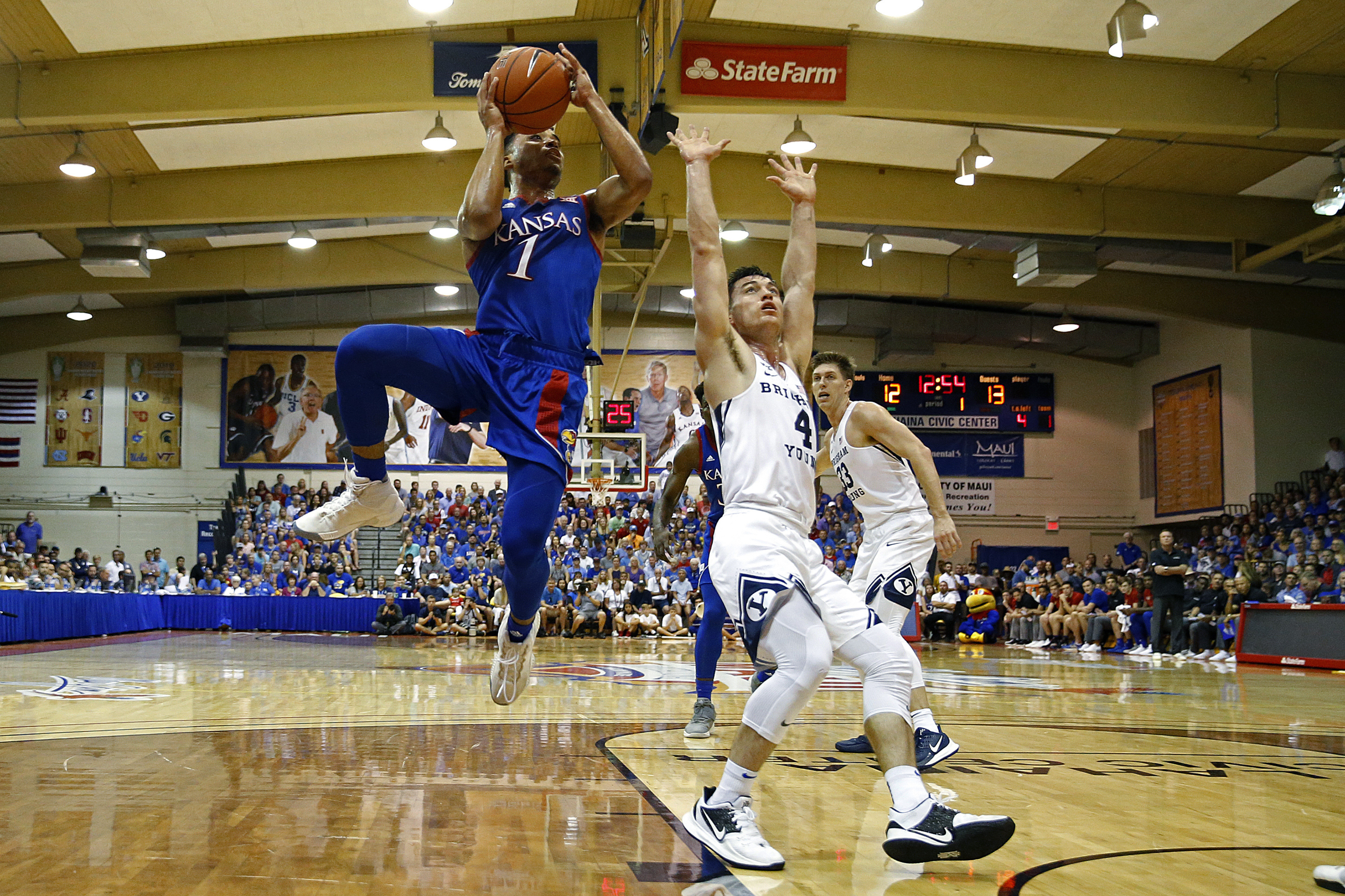 BYU guard Alex Barcello (4) defends Kansas guard Devon Dotson (1) as he shoots during the first half of an NCAA college basketball game, Tuesday, Nov. 26, 2019, in Lahaina, Hawaii. (AP Photo/Marco Garcia)