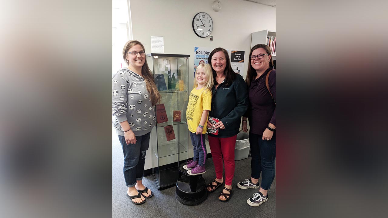 Family gathers to see ancestor's library card found in building’s wall