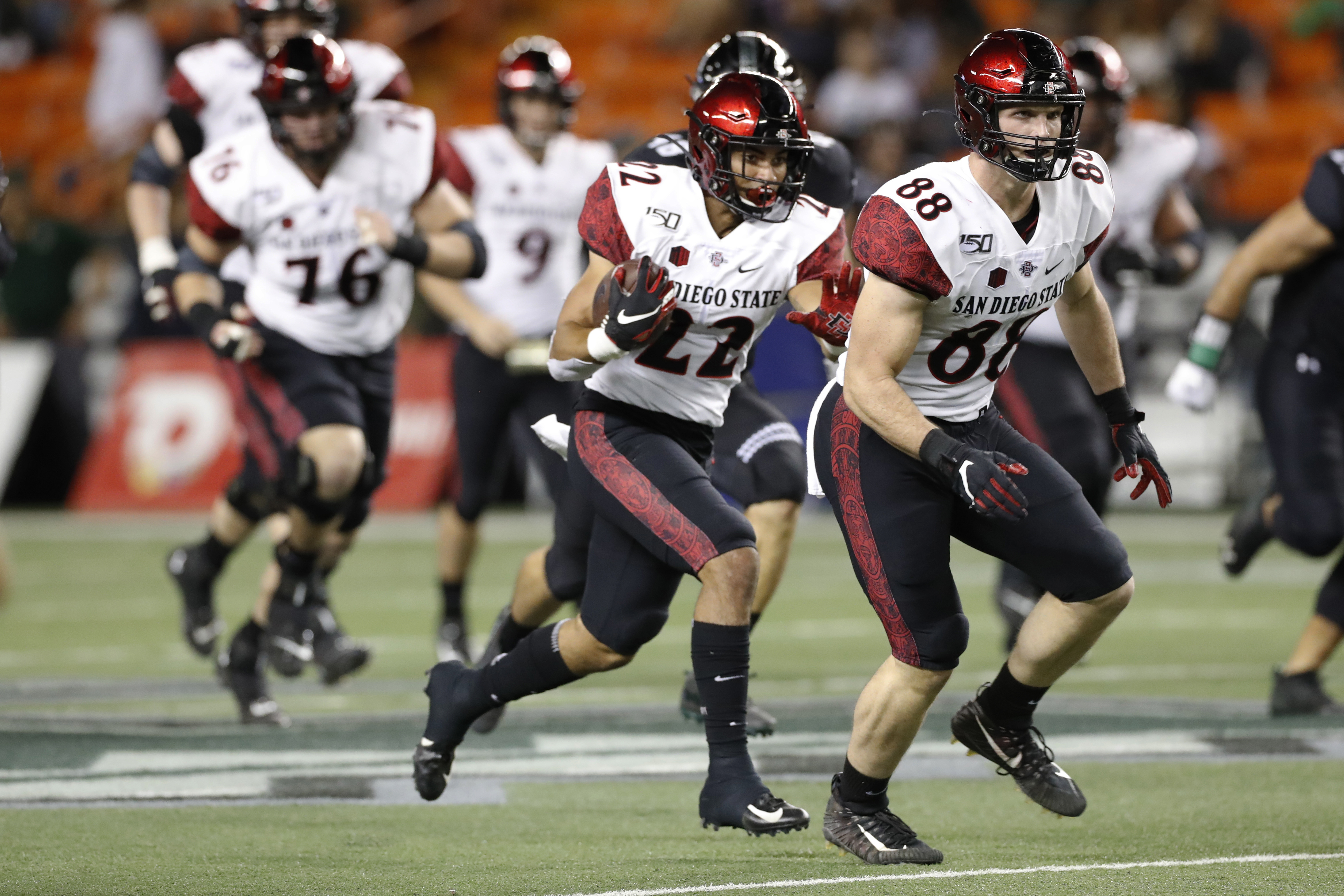 San Diego State tight end Daniel Bellinger (88) leads running back Chase Jasmin (22) through the Hawaii defense during the first half of an NCAA college football game Saturday, Nov. 23, 2019, in Honolulu. (AP Photo/Marco Garcia)