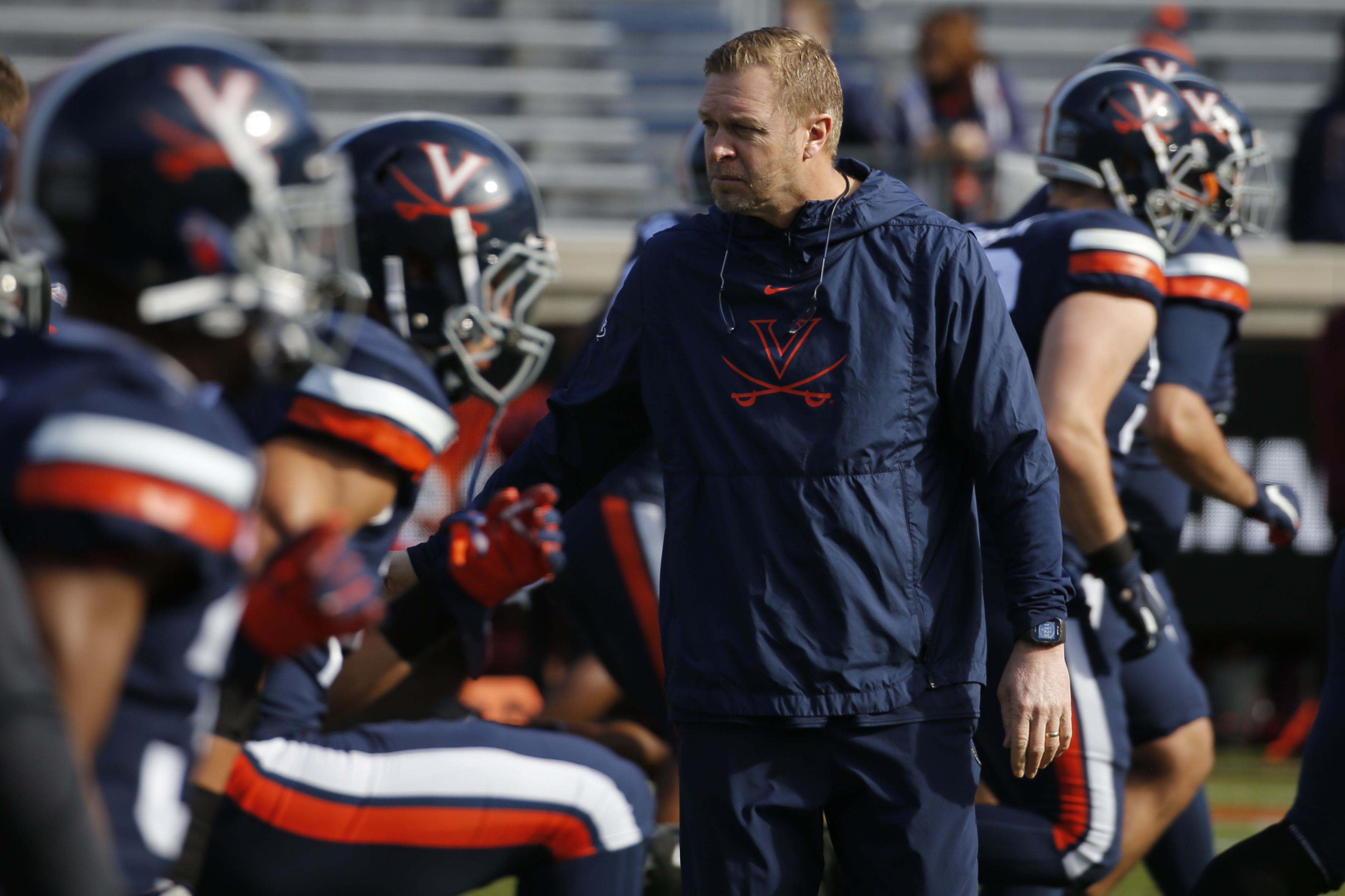 Virginia head coach Bronco Mendenhall watches his team warm up before an NCAA college football game against Virginia Tech in Charlottesville, Va., Friday, Nov. 29, 2019.