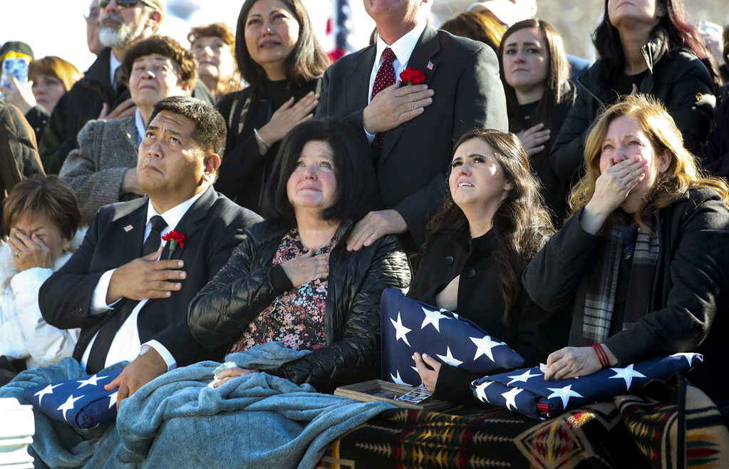 Family members of Chief Warrant Officer 2 Kirk T. Fuchigami Jr. look up as four Apache helicopters fly over graveside services at the Brigham City Cemetery on Monday, Dec. 9, 2019. Picture (l-r) are Kirk Fuchigami, father, Jana Lee Hunsaker Norman, mother-in-law, McKenzie Norman Fuchigami, wife, and Lisa Marie Casey, mother. (Photo: Steve Griffin, KSL)