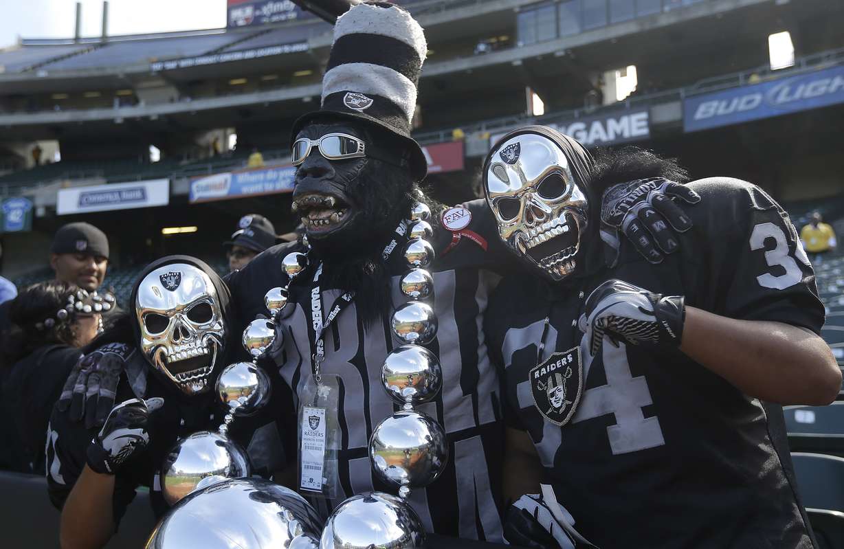 In this Sept. 29, 2013, file photo, Oakland Raiders fan Gorilla Rilla, center, poses for photographs with fans before an NFL football game between the Oakland Raiders and the Washington Redskins in Oakland, Calif. (AP file photo)