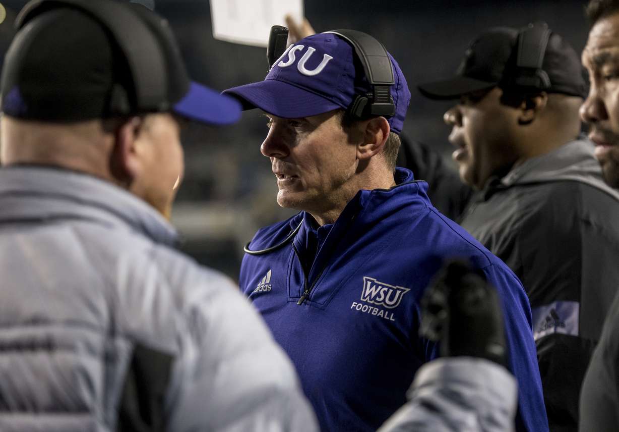 Weber State coach Jay Hill talks with assistants during the first half against James Madison in a semifinal of the NCAA Football Championship Subdivision playoffs in Harrisonburg, Va., Dec. 21, 2019.