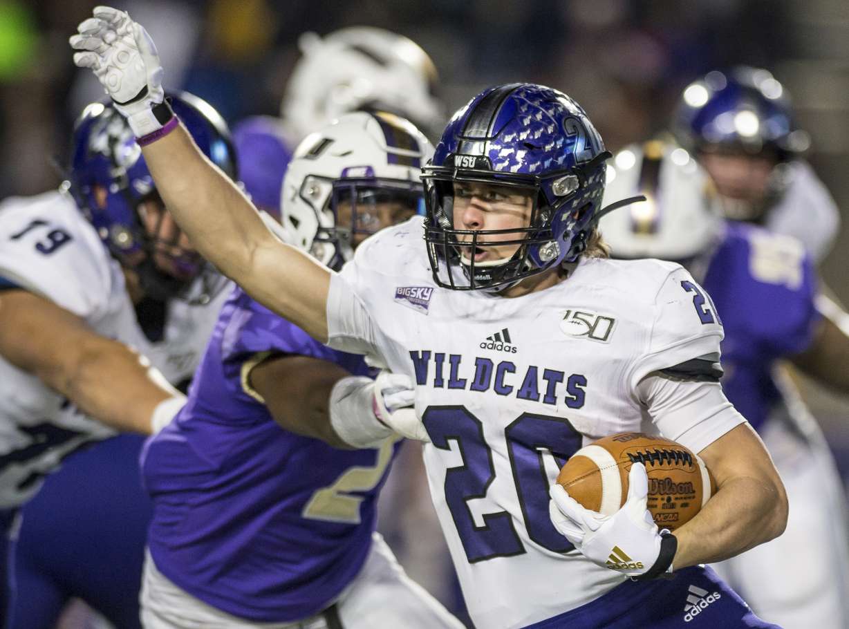 Weber State running back Josh Davis (20) tries to get away from James Madison linebacker Dimitri Holloway (2) during the first half in a semifinal of the NCAA Football Championship Subdivision playoffs in Harrisonburg, Va., Saturday, Dec. 21, 2019.