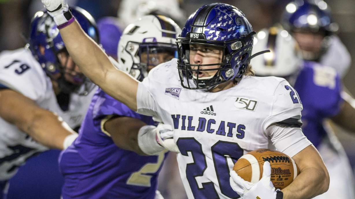 Weber State running back Josh Davis (20) tries to get away from James Madison linebacker Dimitri Holloway (2) during the first half in a semifinal of the NCAA Football Championship Subdivision playoffs in Harrisonburg, Va., Saturday, Dec. 21, 2019. (Daniel Lin/Daily News-Record via AP)