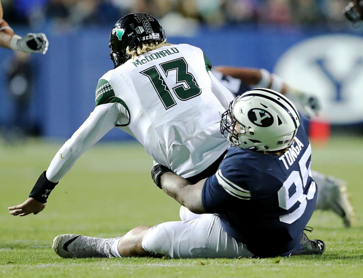 Hawaii Warriors quarterback Cole McDonald (13) is sacked by Brigham Young Cougars defensive lineman Khyiris Tonga (95) as BYU and Hawaii play at LaVell Edwards Stadium in Provo on Saturday, Oct. 13, 2018. (Photo: Scott G Winterton, KSL)