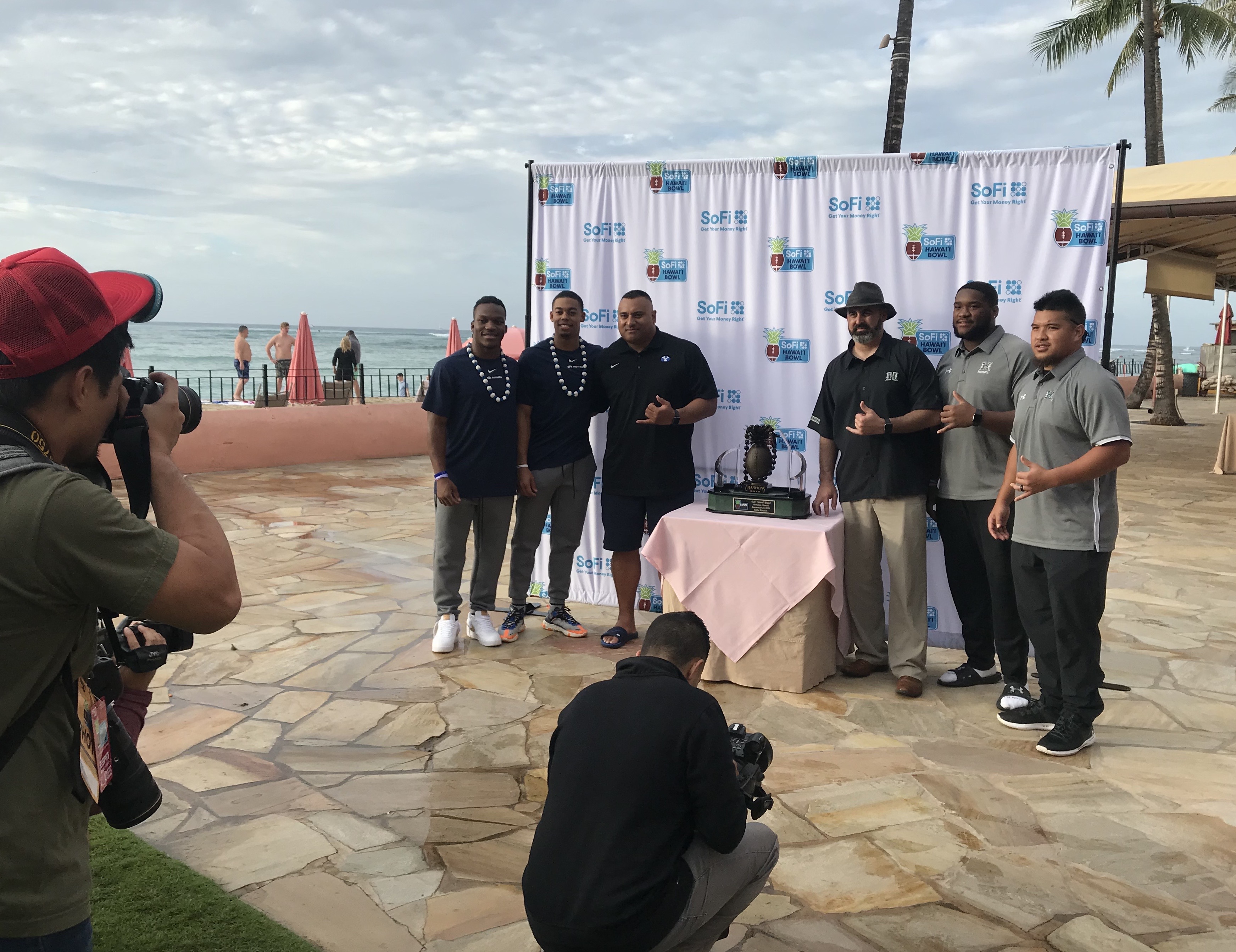 BYU coach Kalani Sitake and Hawaii's Nick Rolovich, middle, pose with players and the trophy for the SoFi Hawaii Bowl during a pregame press conference, Monday, Dec. 23, 2019 in Honolulu, Hawaii. (Photo: Sean Walker, KSL.com)