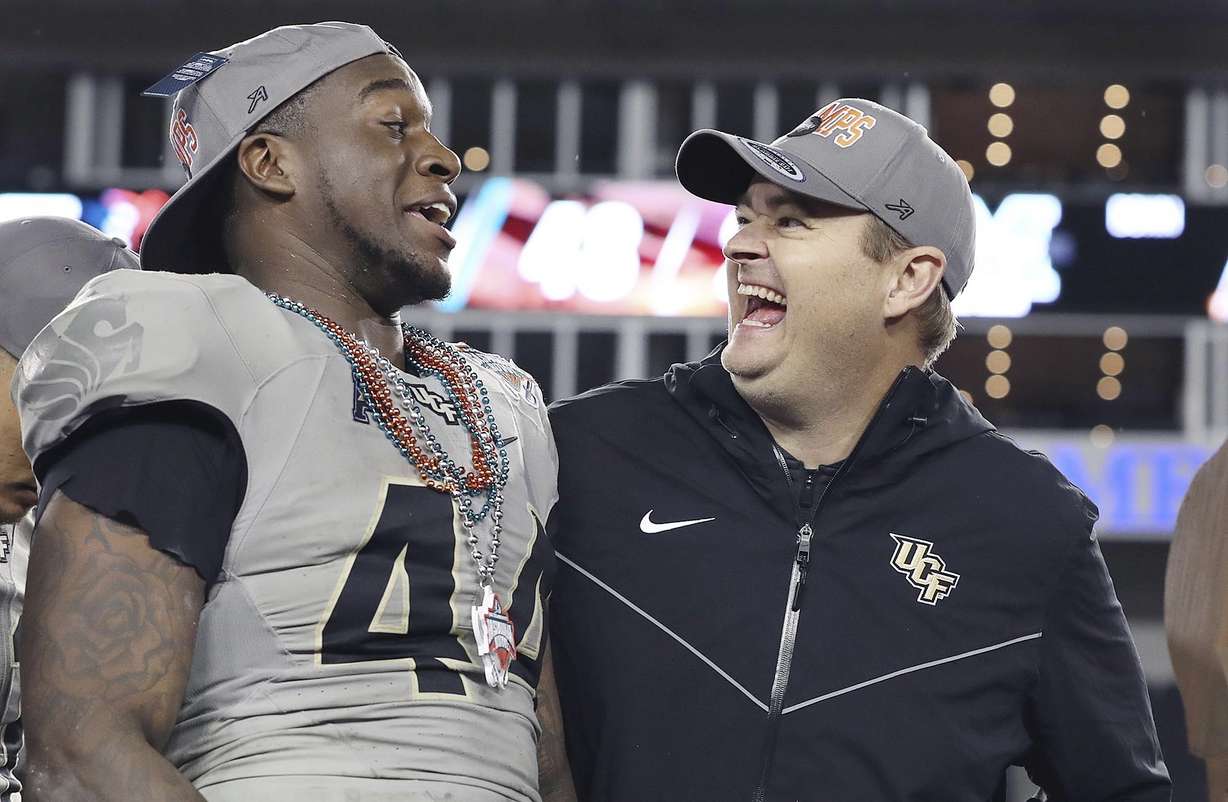 Central Florida linebacker Nate Evans, left, and coach Josh Heupel smile after the team's win over Marshall in the Gasparilla Bowl NCAA college football game Monday, Dec. 23, 2019, in Tampa, Fla.