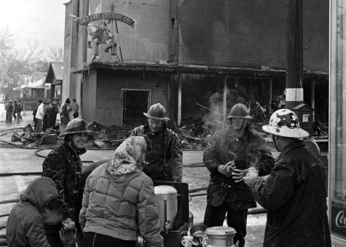 Fire crews confer with each other across the street from the Salt Lake Costume Company on Jan. 11, 1963, after a fire damaged a good portion of the building. The company's sign, which can be seen in the top right portion of the photo, was not severely damaged in the blaze. (Photo: Utah State History)