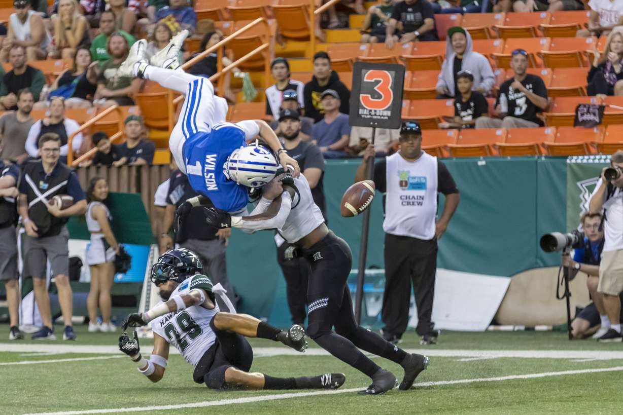 BYU quarterback Zach Wilson (1) loses the football on a hit by Hawaii defensive back Eugene Ford, right, as Wilson tried to leap into the end zone during the second half of the Hawaii Bowl NCAA college football game Tuesday, Dec. 24, 2019, in Honolulu. Hawaii recovered the football in the end zone for a touchback. (Photo: Eugene Tanner, AP)