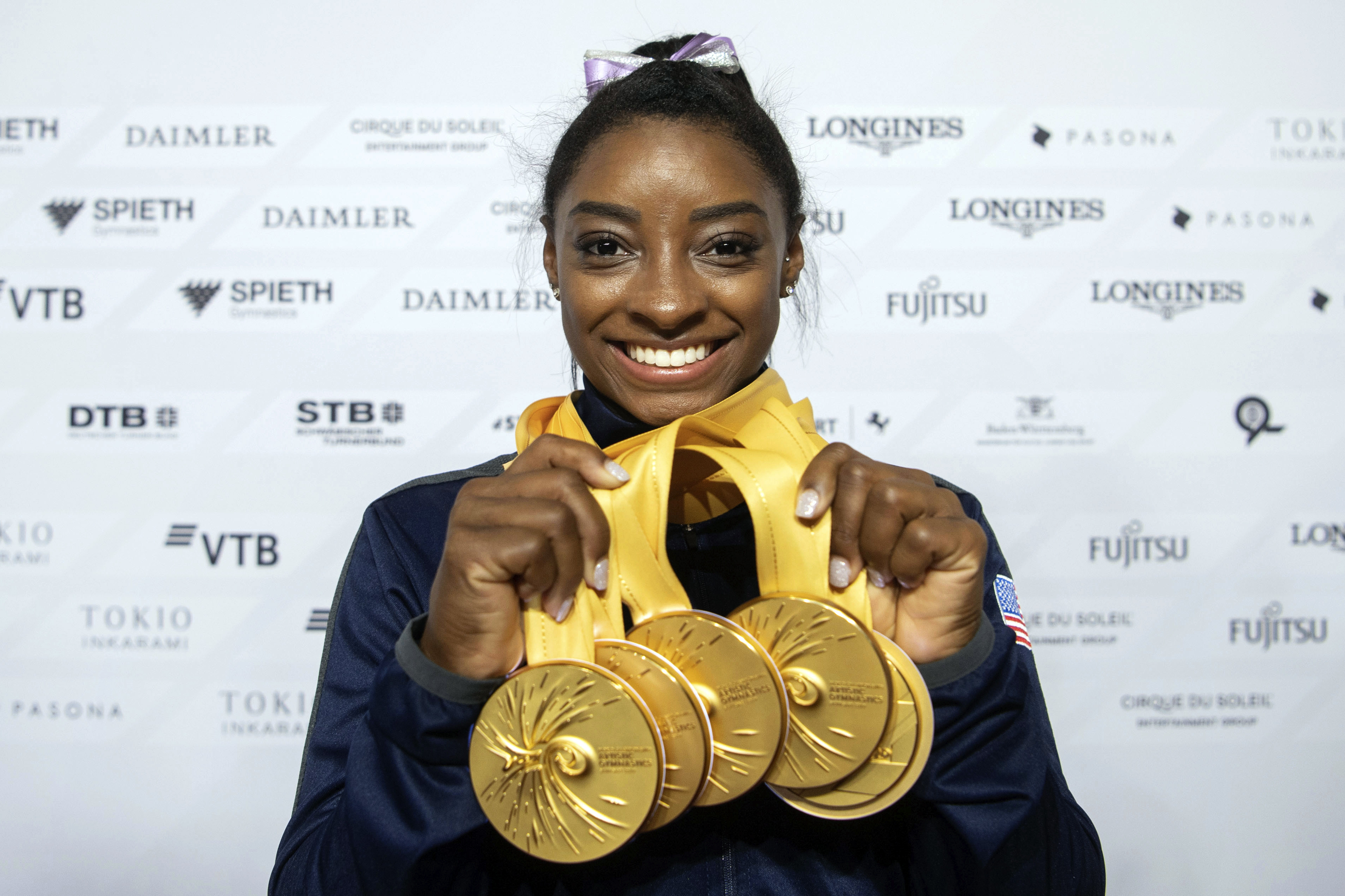 This Oct. 13, 2019, file photo Simone Biles of the United States shows her five gold medals at the Gymnastics World Championships in Stuttgart, Germany. Biles is the 2019 AP Female Athlete of the Year. She is the first gymnast to win the award twice and the first to win it in a non-Olympic year. (Photo: Marijan Murat/dpa via AP, File)