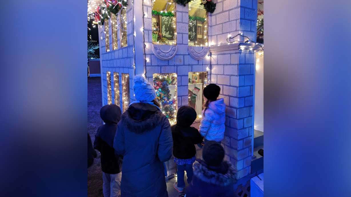 Elizabeth Reid and her children peeking into one of the houses at the Christmas Village in Ogden. (Photo: Courtesy Elizabeth Reid)