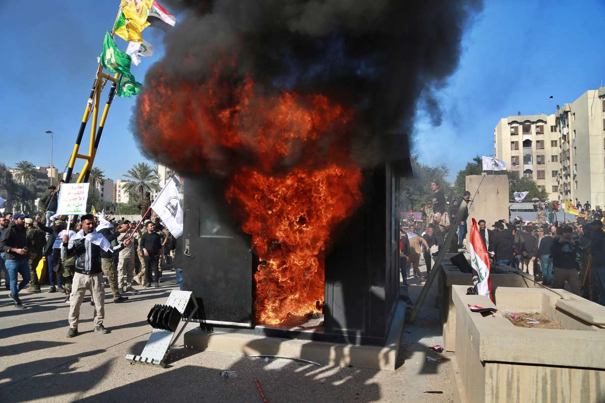 Protesters burn property in front of the U.S. embassy compound, in Baghdad, Iraq, Tuesday, Dec. 31, 2019. Dozens of angry Iraqi Shiite militia supporters broke into the U.S. Embassy compound in Baghdad on Tuesday after smashing a main door and setting fire to a reception area, prompting tear gas and sounds of gunfire. (Khalid Mohammed, AP Photo)