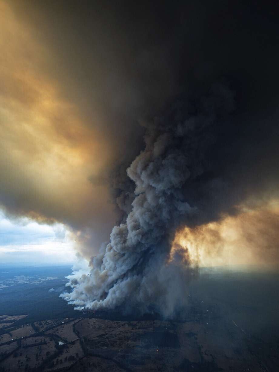 In this image released Thursday, Jan. 2, 2020, from the Department of Environment, Land, Water and Planning in Gippsland, Australia, a massive smoke rises from wildfires burning in East Gippsland, Victoria. Thousands of tourists are fleeing Australia's wildfire-ravaged eastern coast ahead of worsening conditions as the military started to evacuate people trapped on the shore further south. Cooler weather has aided firefighting and allowed people to replenish supplies. (DELWP Gippsland via AP)