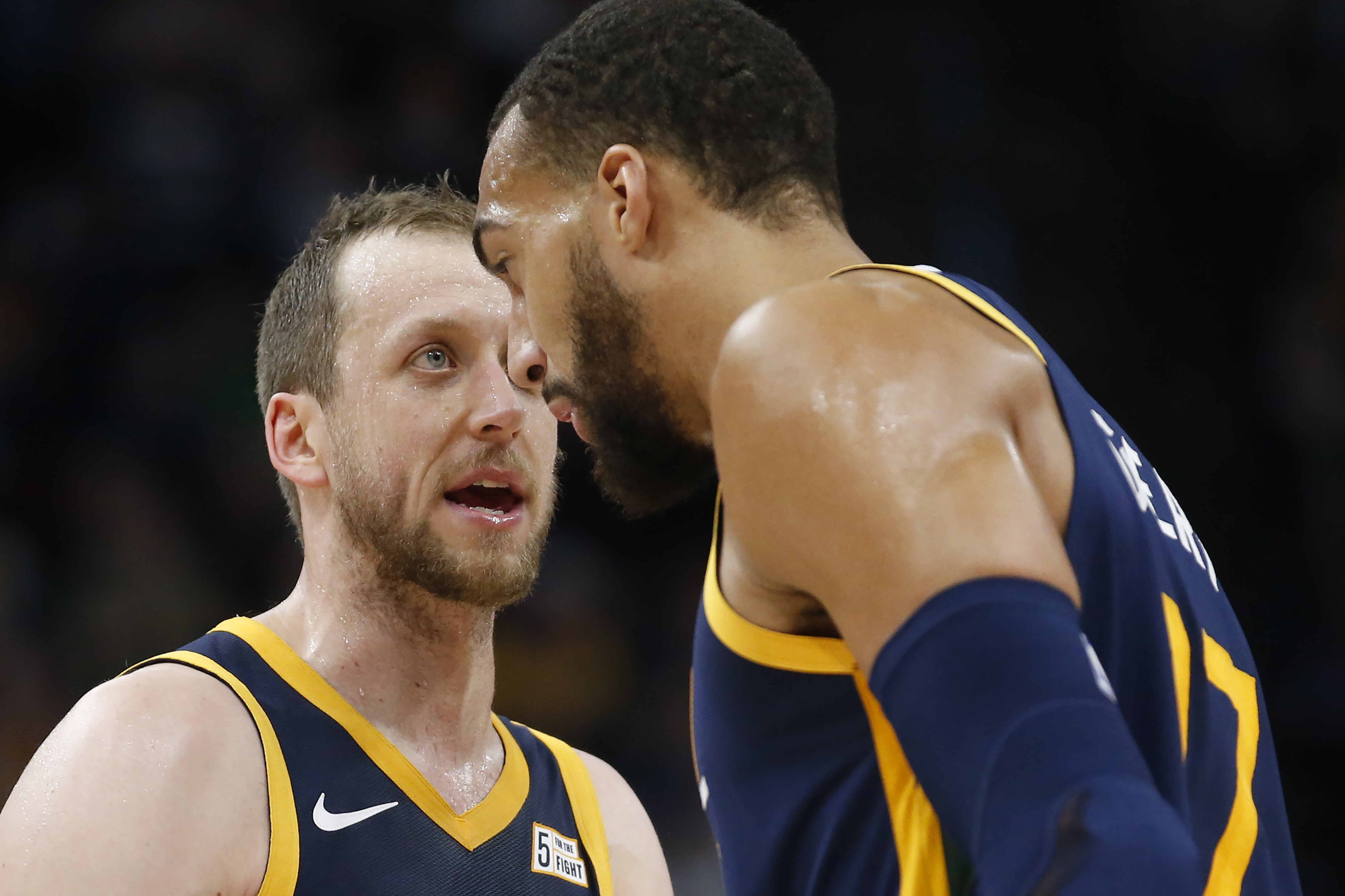 Utah Jazz's Joe Ingles, left, and Rudy Gobert, right, have a discussion in the second half during an NBA basketball game against the Golden State Warriors Friday, Dec. 13, 2019, in Salt Lake City. (AP Photo/Rick Bowmer)